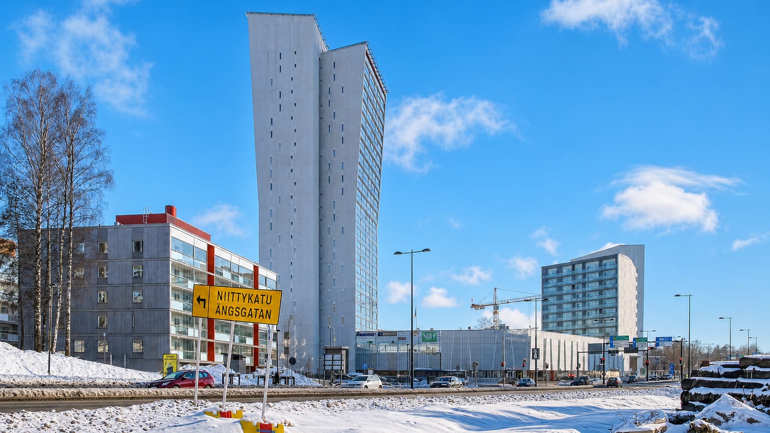 Niittykumpu, Espoo, Finland: the slim white Niittyhuippu tower above snowy streets and a Niittykatu street sign.