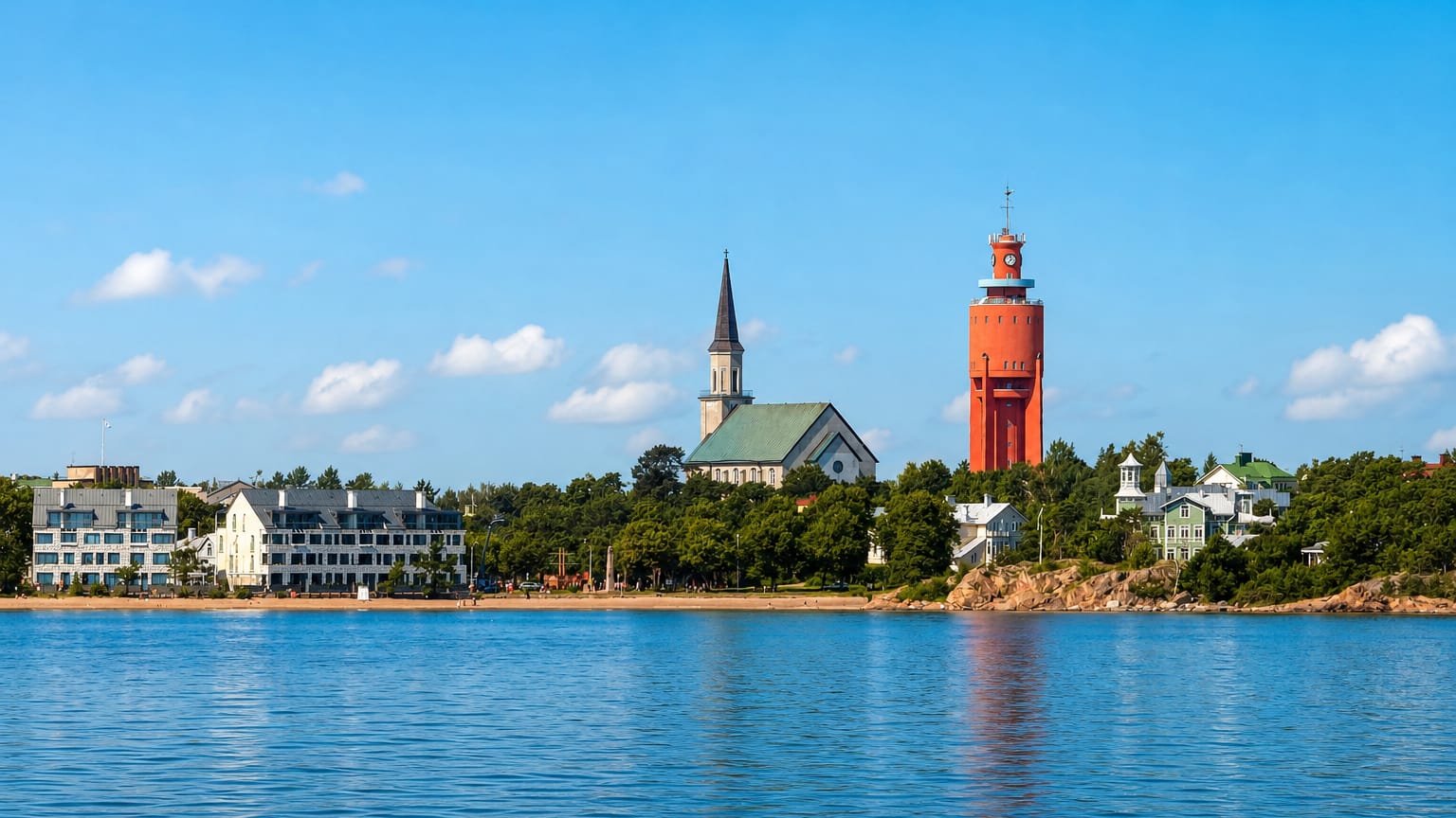 Hanko seafront skyline with its red brick water tower, green-spired church and white wooden villas under a blue sky.
