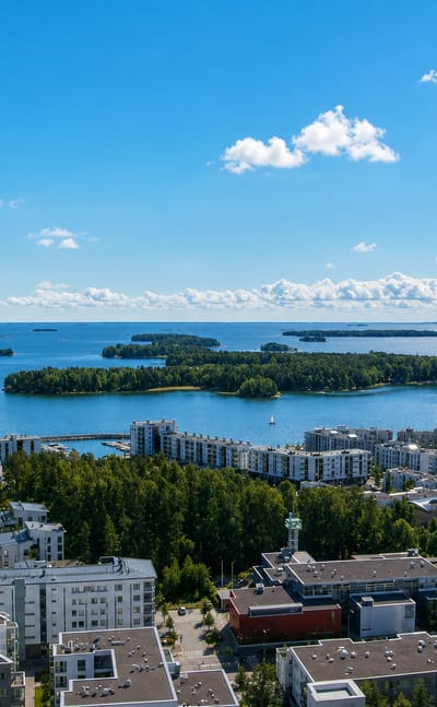 Aurinkolahti, Helsinki: white waterfront apartment blocks and a marina facing the wooded Gulf of Finland islands.