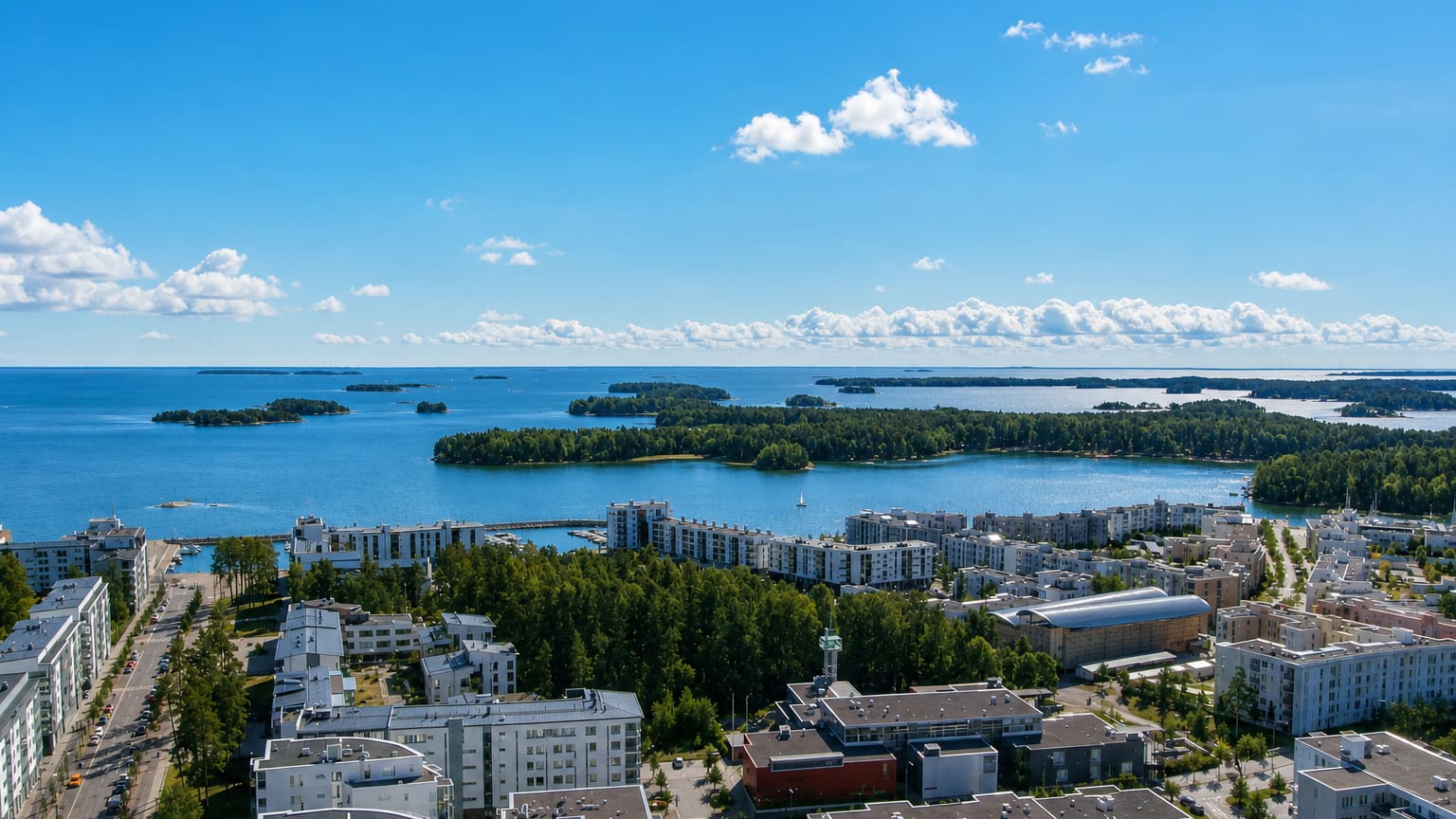Aurinkolahti, Helsinki: white waterfront apartment blocks and a marina facing the wooded Gulf of Finland islands.