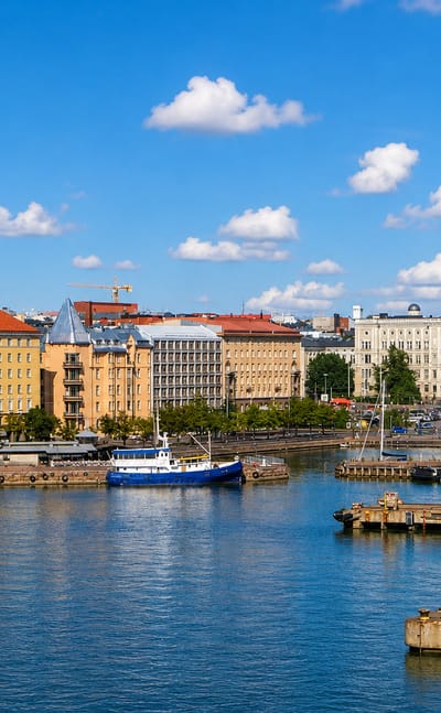 Hietalahti harbour in Helsinki with moored boats, a shipyard crane and quayside apartment blocks.