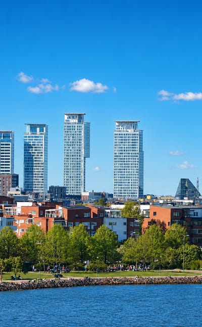 Kalasatama's waterfront cluster of modern high-rise towers above red-brick apartments and a seaside park, Helsinki, Finland