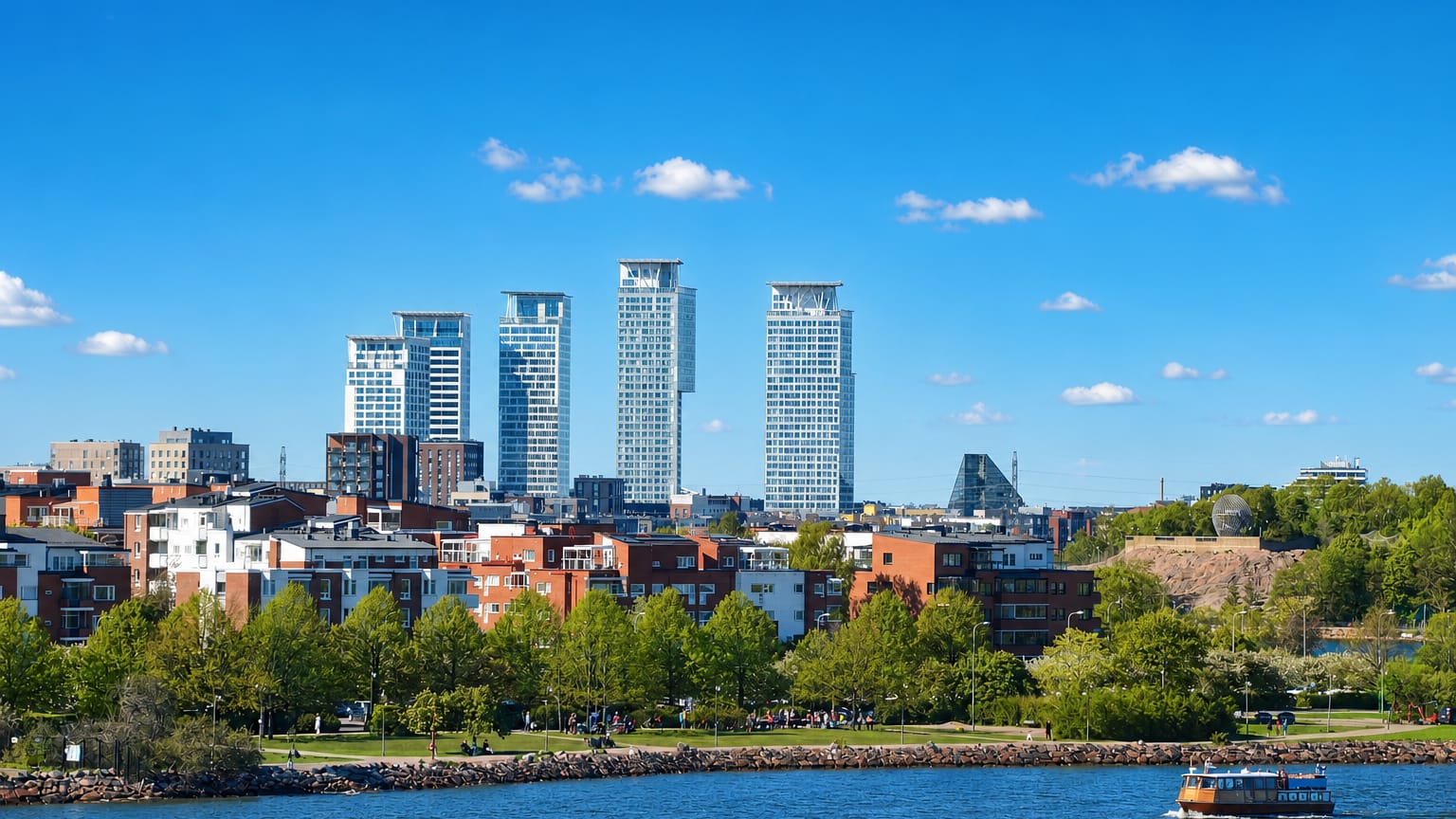 Kalasatama's waterfront cluster of modern high-rise towers above red-brick apartments and a seaside park, Helsinki, Finland