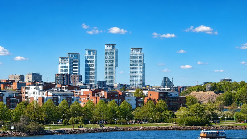 Kalasatama's waterfront cluster of modern high-rise towers above red-brick apartments and a seaside park, Helsinki, Finland