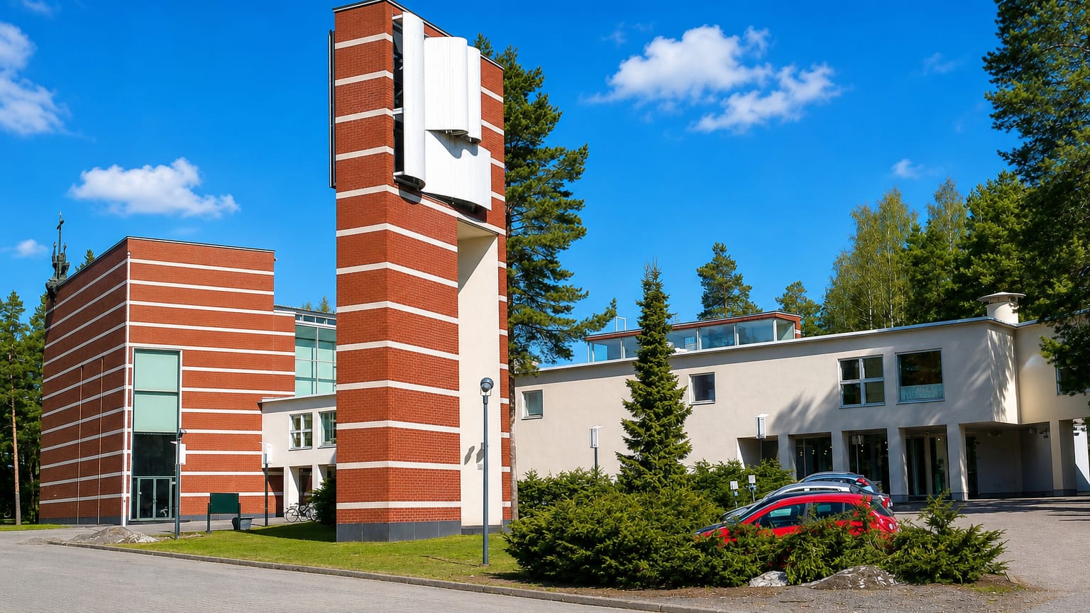 Red-brick modernist church and low white buildings among pines in Kontula, eastern Helsinki.