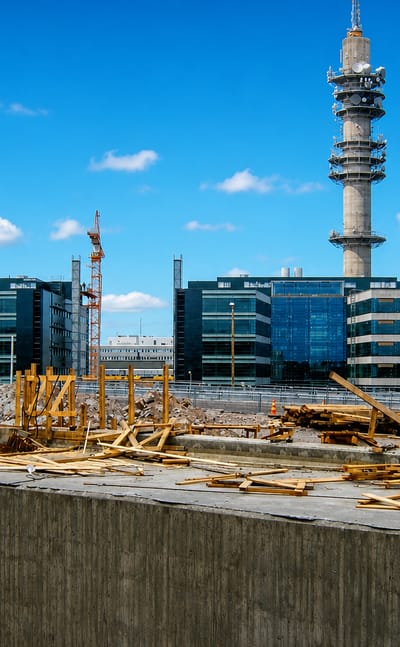 Pasila Link Tower and glass office buildings in Länsi-Pasila, Helsinki, beyond a foreground construction site under blue sky