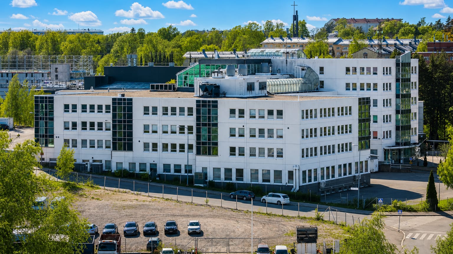 A white modernist office block above a parking area in Roihuvuori, a leafy residential district of eastern Helsinki.