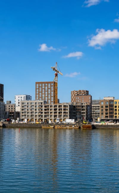 New waterfront apartment blocks under construction in Sompasaari, Helsinki, with power-plant chimneys behind.