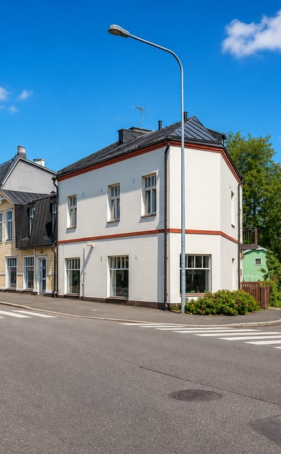 Quiet corner of white and wooden low-rise houses in Tapanila, Helsinki, on a clear summer day
