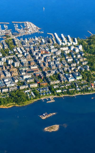 Aerial view of Vattuniemi peninsula in Helsinki, with its marina, apartment blocks and surrounding sea archipelago.