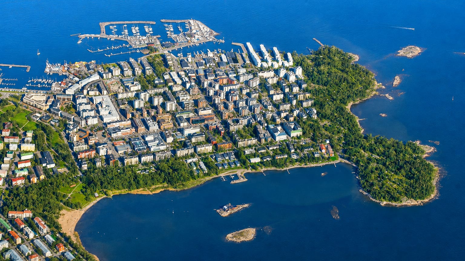 Aerial view of Vattuniemi peninsula in Helsinki, with its marina, apartment blocks and surrounding sea archipelago.