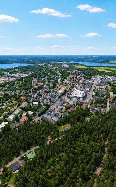 Aerial view of Lohja, Finland, a lakeside town on Lake Lohjanjärvi ringed by forest, with a marina and compact town centre