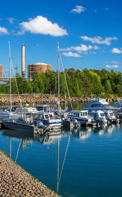 Lovisa marina with moored sailboats and motorboats backed by the twin reactor domes of the Loviisa nuclear power plant