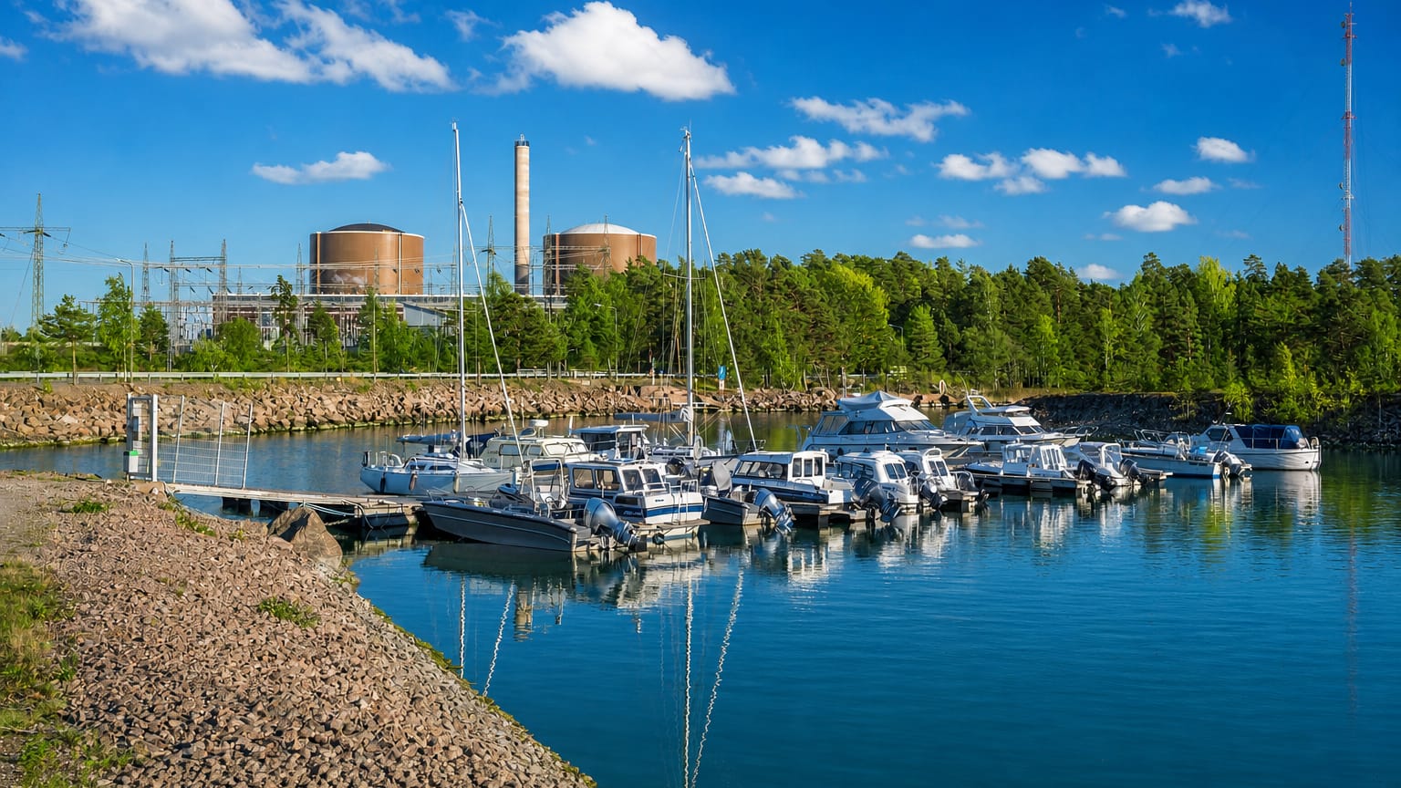 Lovisa marina with moored sailboats and motorboats backed by the twin reactor domes of the Loviisa nuclear power plant