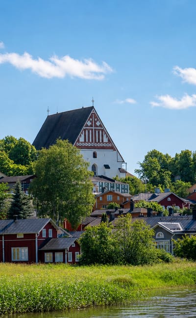 Porvoo's medieval cathedral on the hill above the historic red riverside warehouse houses along the Porvoo River.