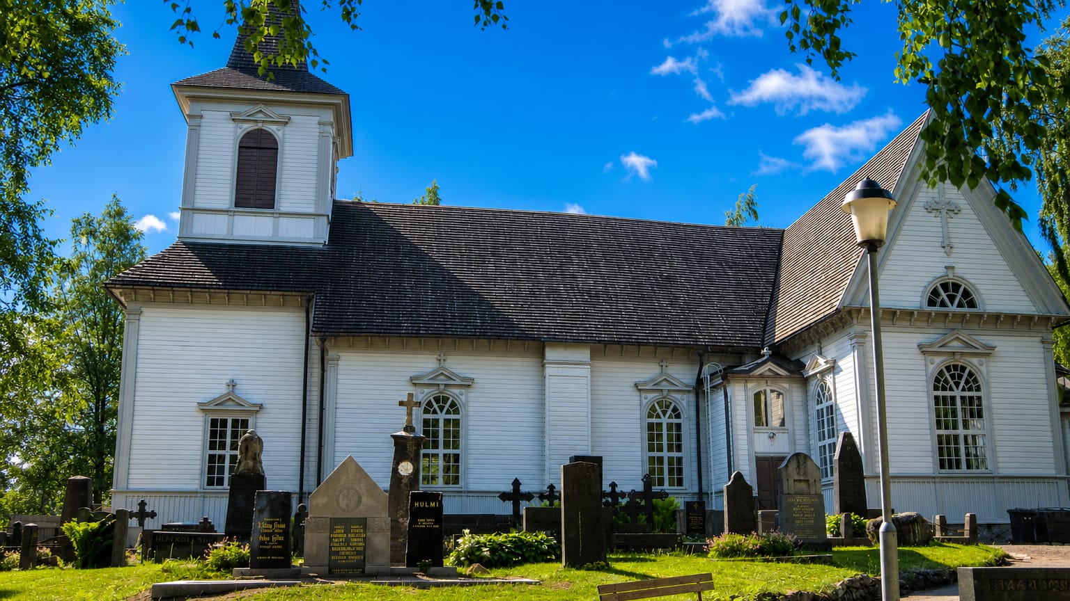 Alastaro's white wooden church with a bell tower rising above its graveyard of headstones and stone crosses.