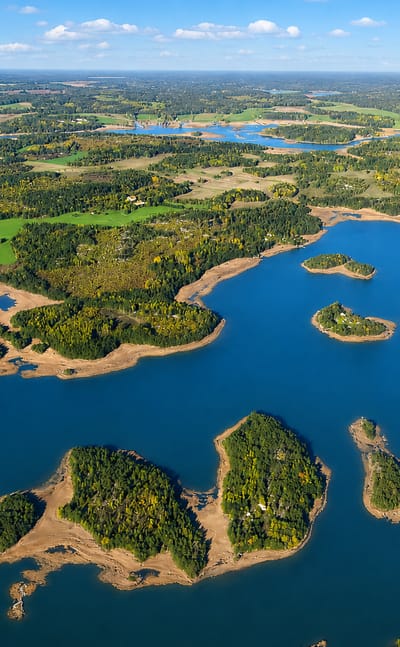 Aerial view of forested islands scattered across the blue archipelago waters around Askainen, Finland.