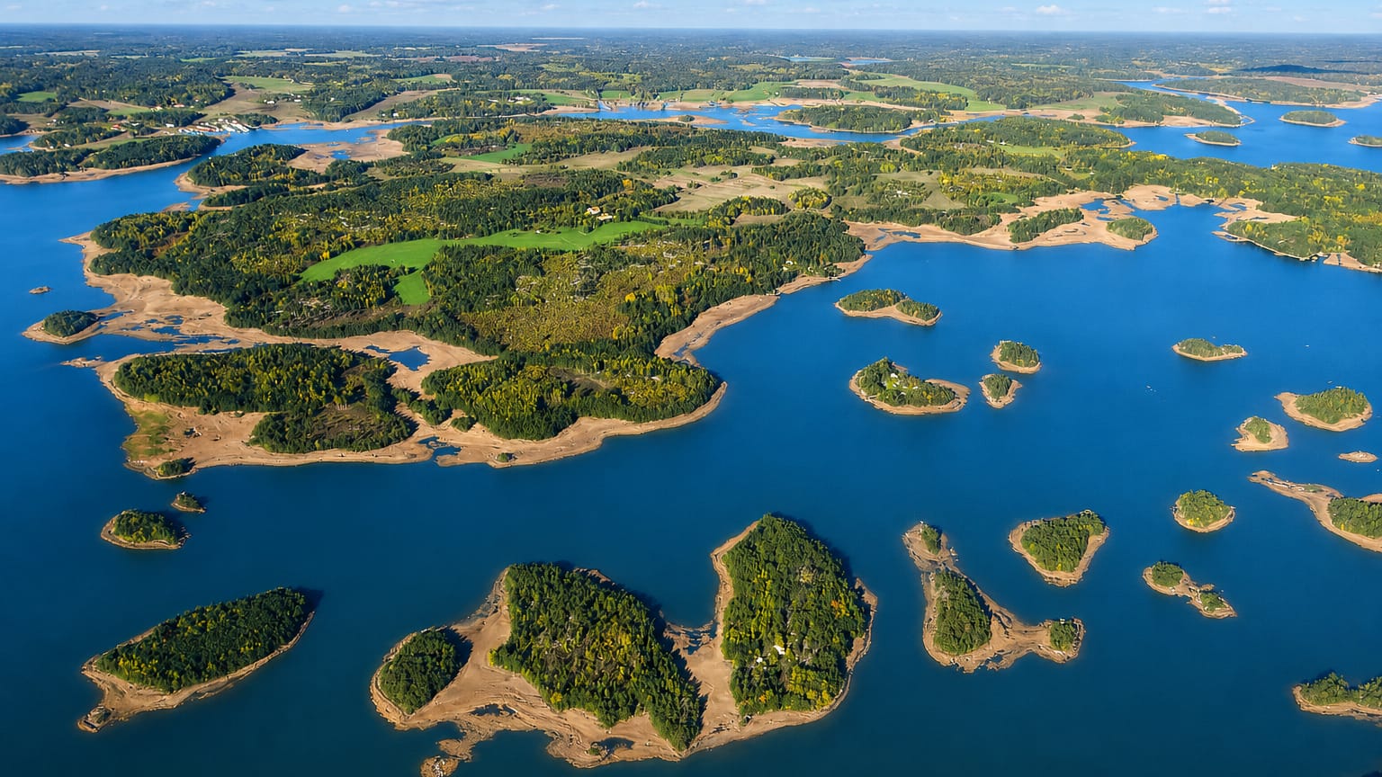 Aerial view of forested islands scattered across the blue archipelago waters around Askainen, Finland.