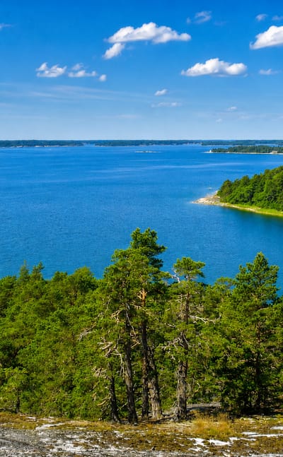 Forested rocky islets and open blue waters of Iniö in Finland's Archipelago Sea on a clear summer day
