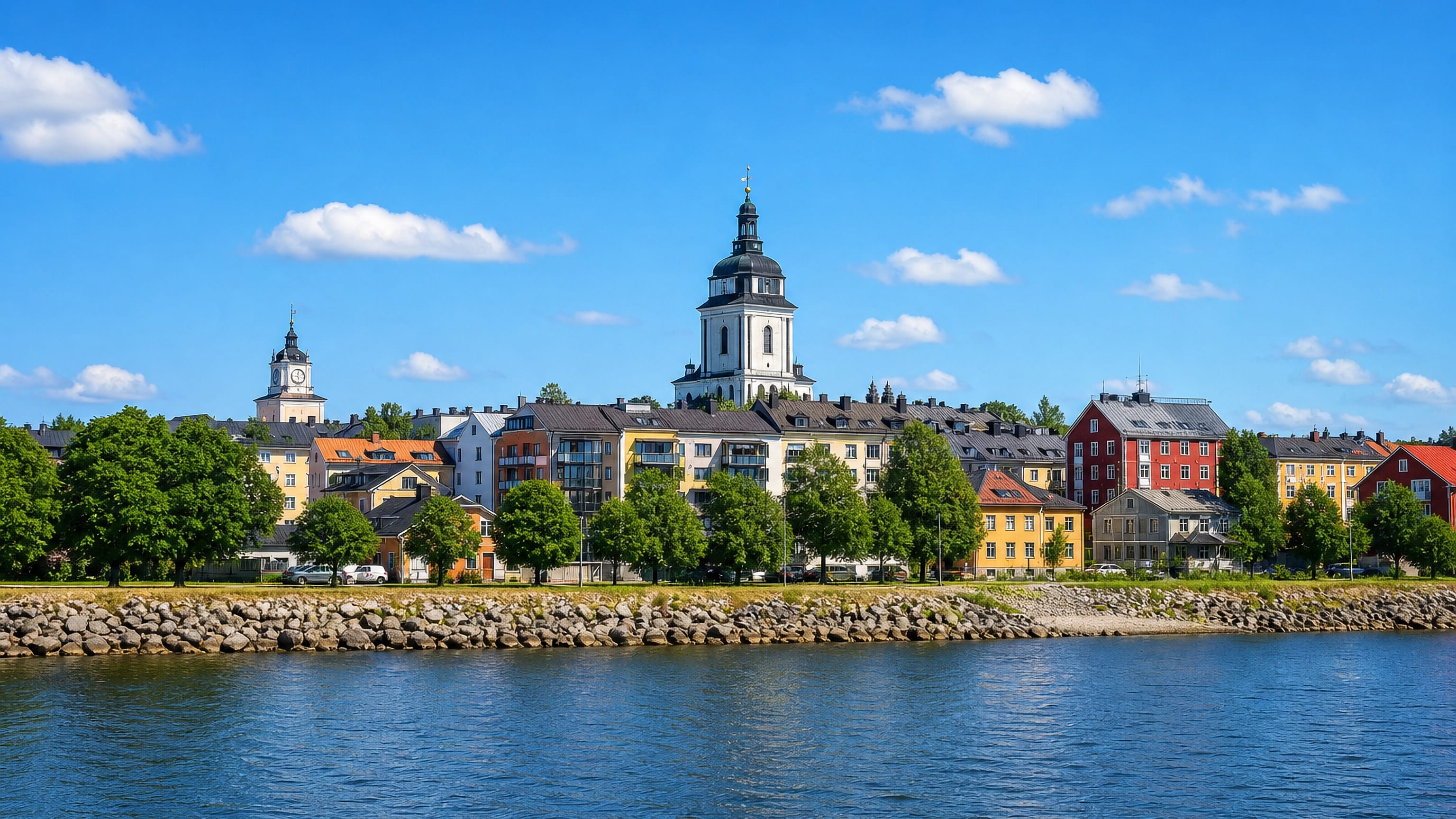 Waterfront rooftops and a domed church tower across the water at Hannunniittu, Turku.
