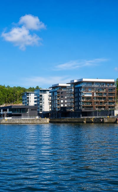 Waterfront apartment blocks on the rocky wooded slope of Korppolaismäki, seen across the water in Turku.