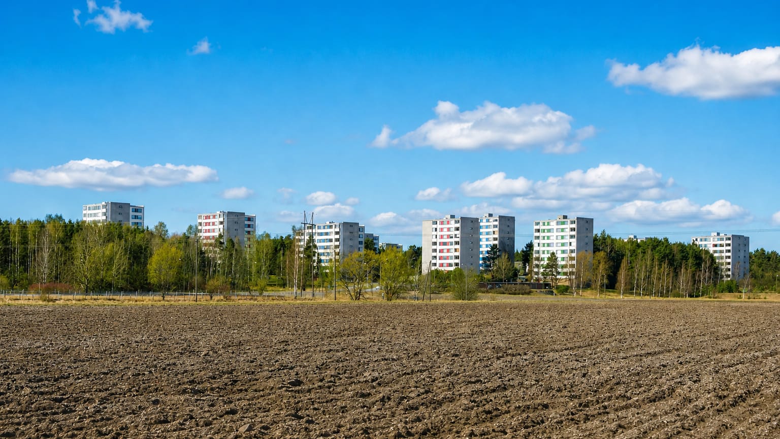 Vätti on the edge of Turku, with apartment blocks standing behind a birch treeline above a ploughed field.