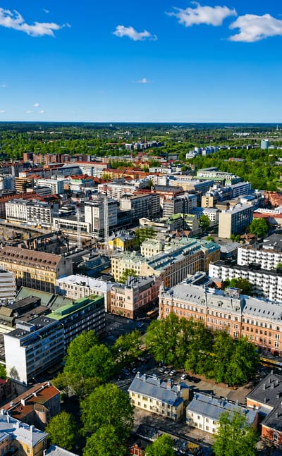 Aerial daytime view of central Turku's VI kaupunginosa, with mid-rise buildings, parks and the Aura River