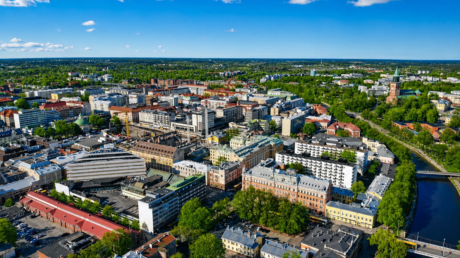 Aerial daytime view of central Turku's VI kaupunginosa, with mid-rise buildings, parks and the Aura River