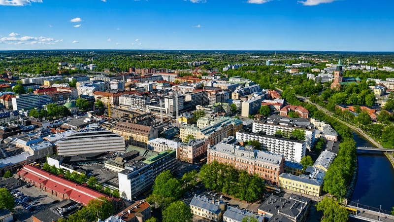 Aerial daytime view of central Turku's VI kaupunginosa, with mid-rise buildings, parks and the Aura River