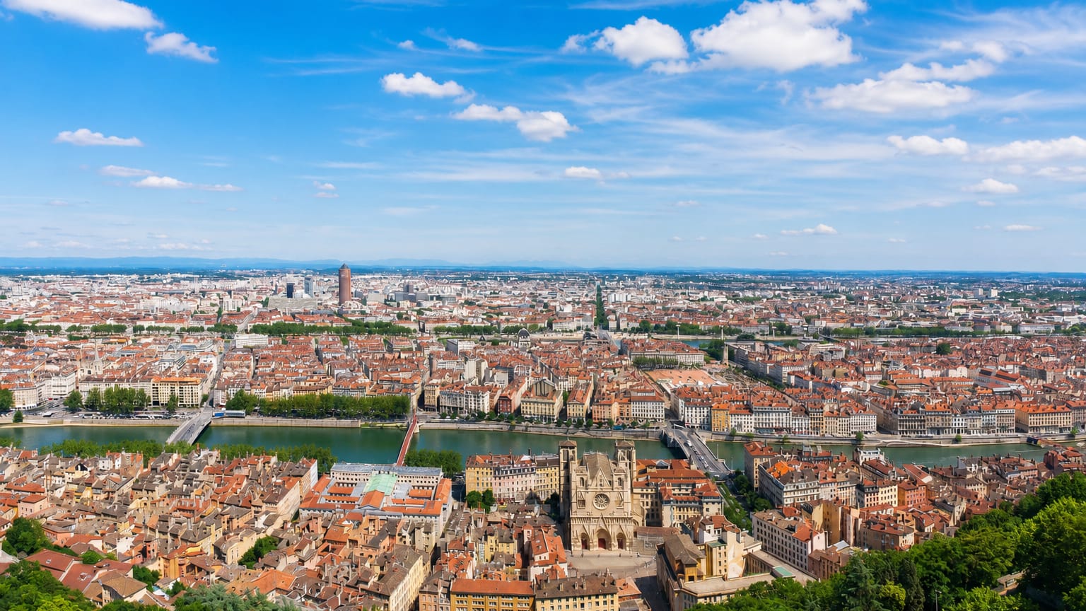 Panorama of Lyon from Fourviere over the old town, the Saone river and its bridges under a blue sky.