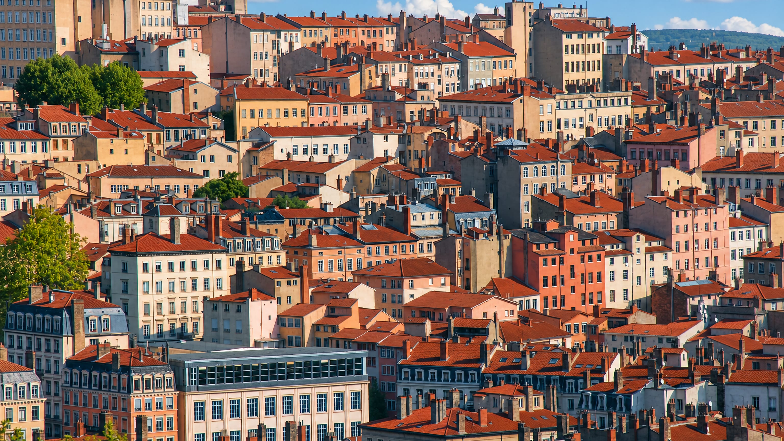 Red-tiled roofs and ochre facades packed across the Croix-Rousse hillside above Lyon, France.