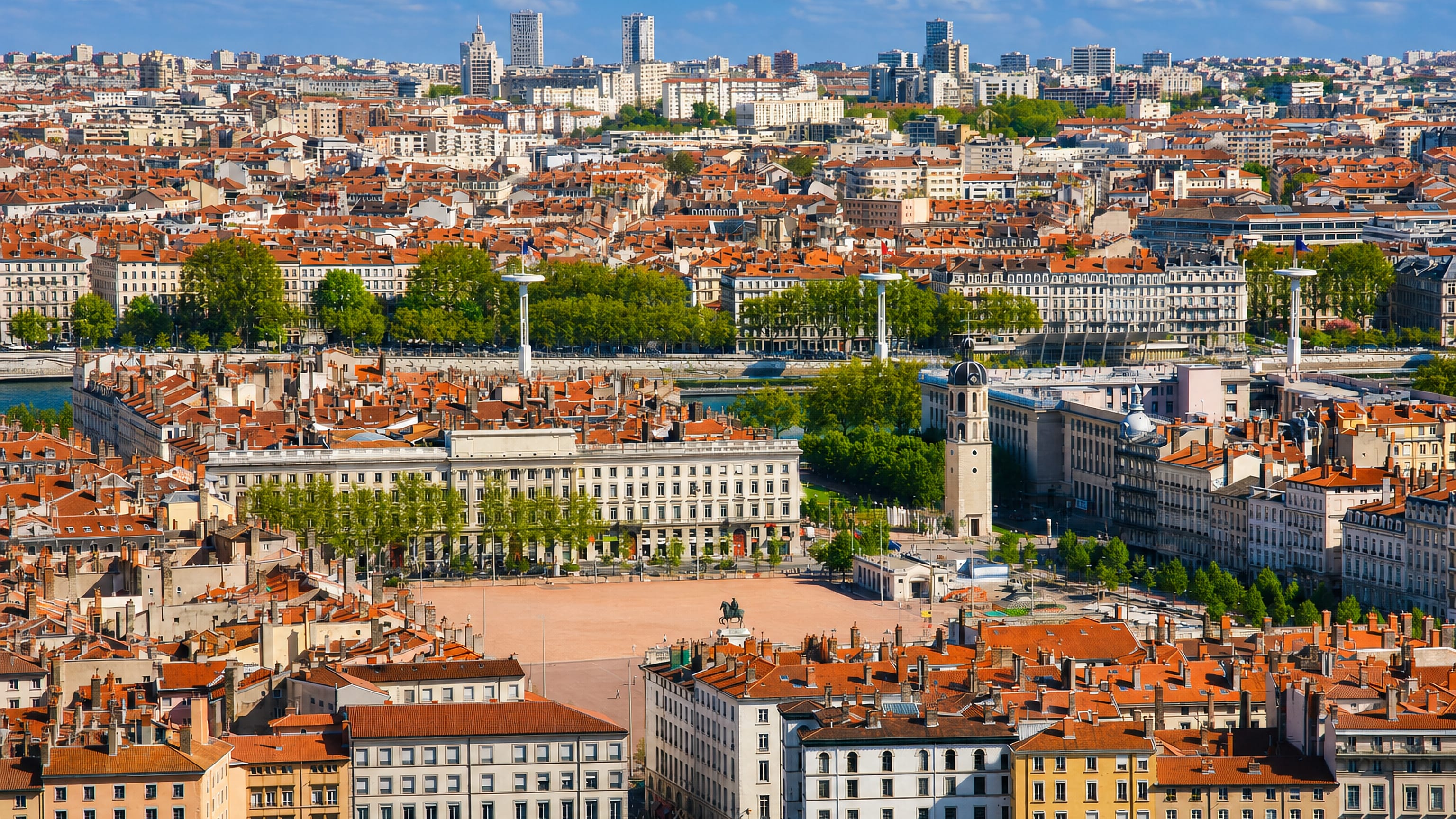 Aerial view of Lyon 02 with Place Bellecour, the Charity bell tower and red-tiled rooftops by the rivers.
