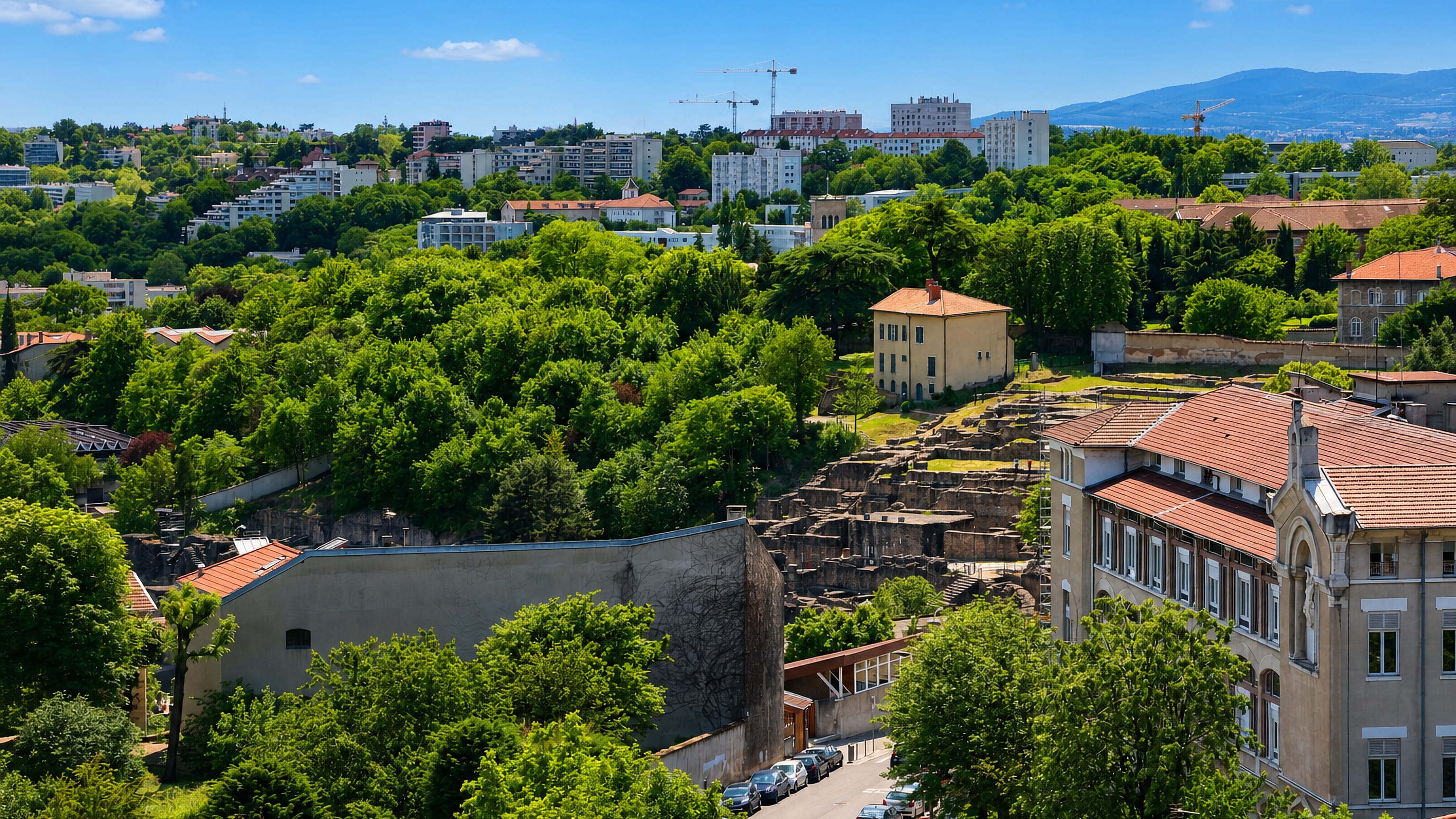 Roman theatre ruins and red-tiled roofs on the wooded Fourviere hillside of Lyon's 5th arrondissement.
