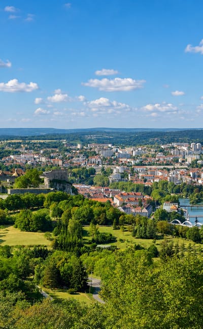 Aerial view of Besancon with Vauban's hilltop Citadelle above the Doubs river loop and wooded hills