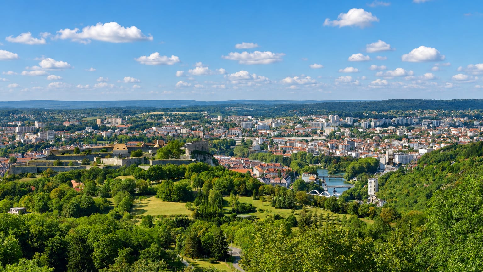 Aerial view of Besancon with Vauban's hilltop Citadelle above the Doubs river loop and wooded hills