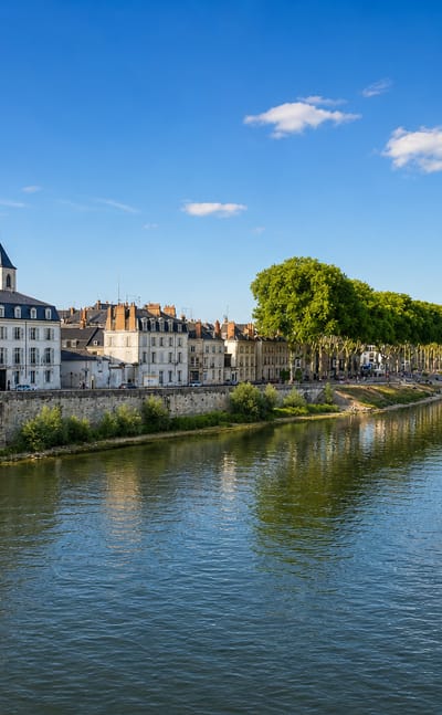 The Loire flows past Orléans' historic quayside, the twin spires of Sainte-Croix Cathedral rising behind the old rooftops.