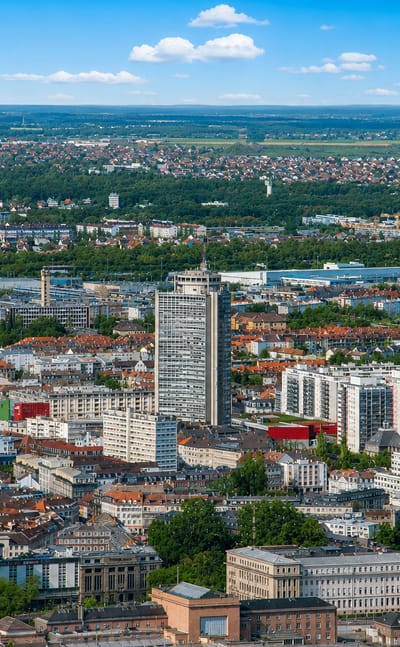 Aerial view of Mulhouse with the dark Gothic spire of Temple Saint-Etienne among tower blocks and rooftops