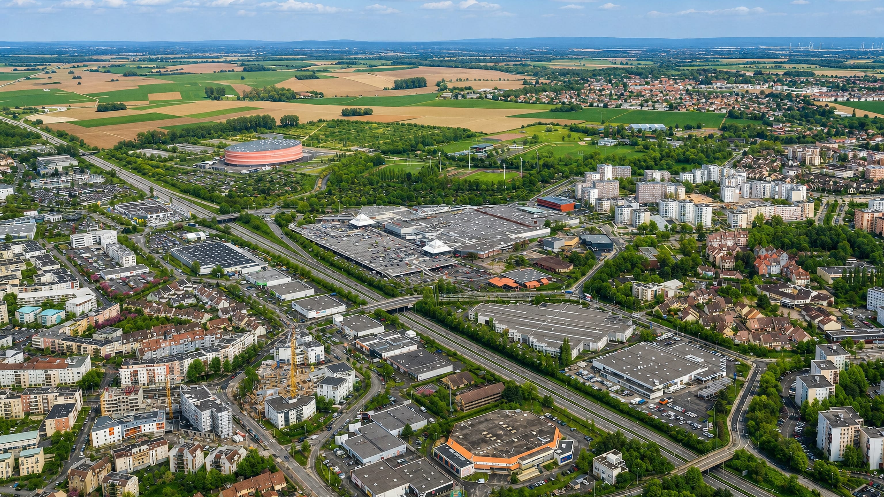 Aerial view over Hautepierre in Strasbourg, its arena, shopping centre and motorway edged by Alsace farmland