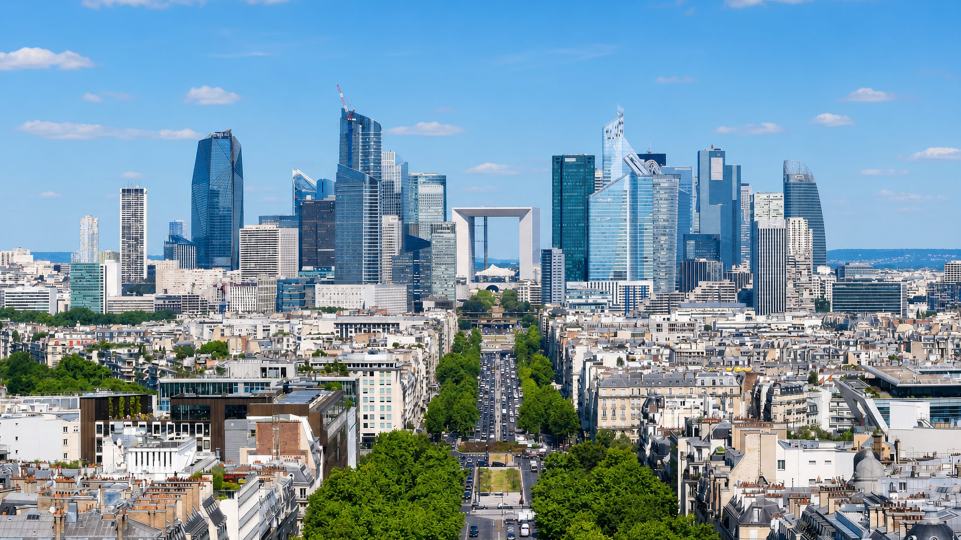 La Défense skyscrapers and the Grande Arche seen down a tree-lined avenue from central Paris.