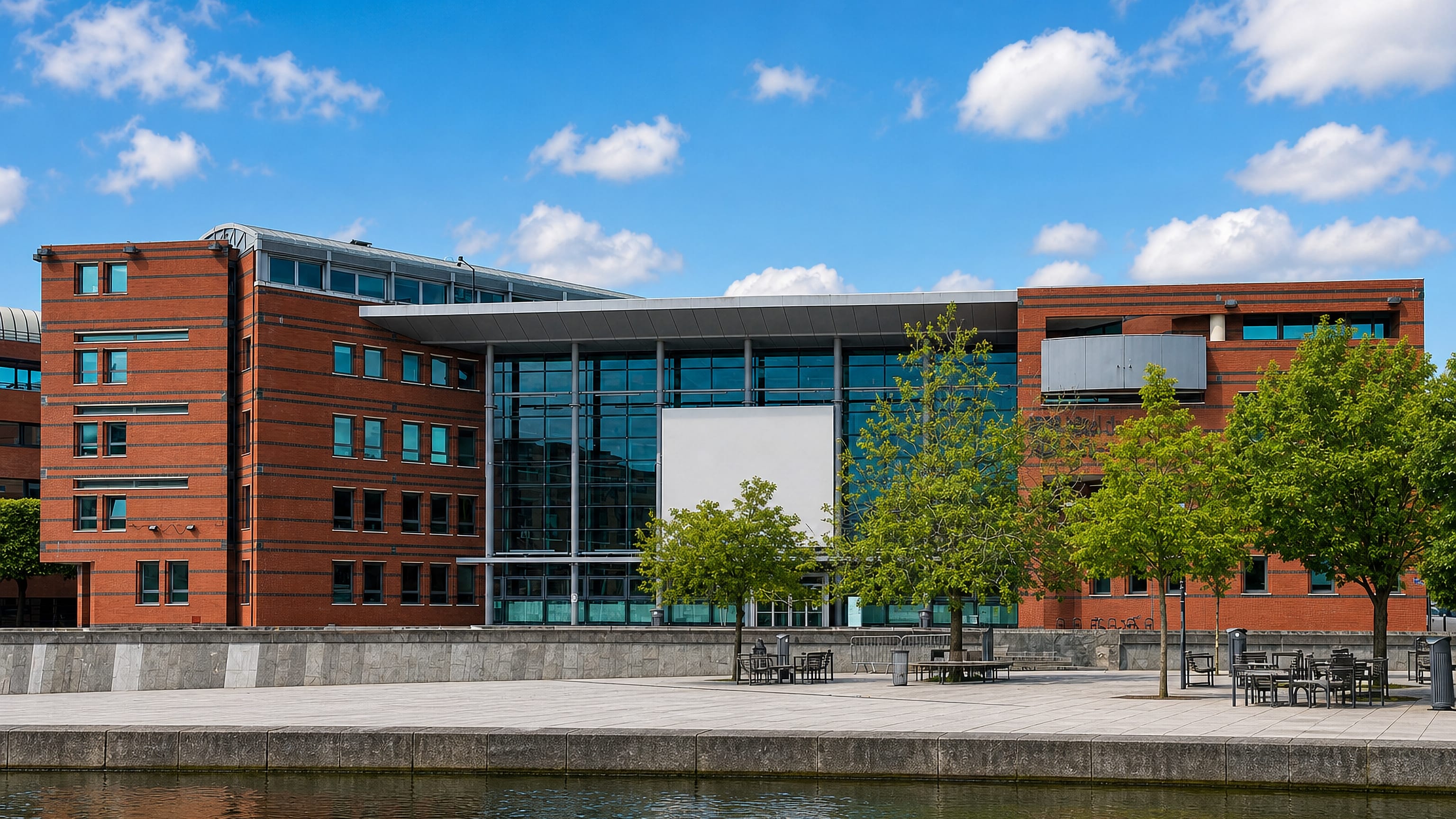 A modern red-brick and glass office building beside the water in Évry, south of Paris.