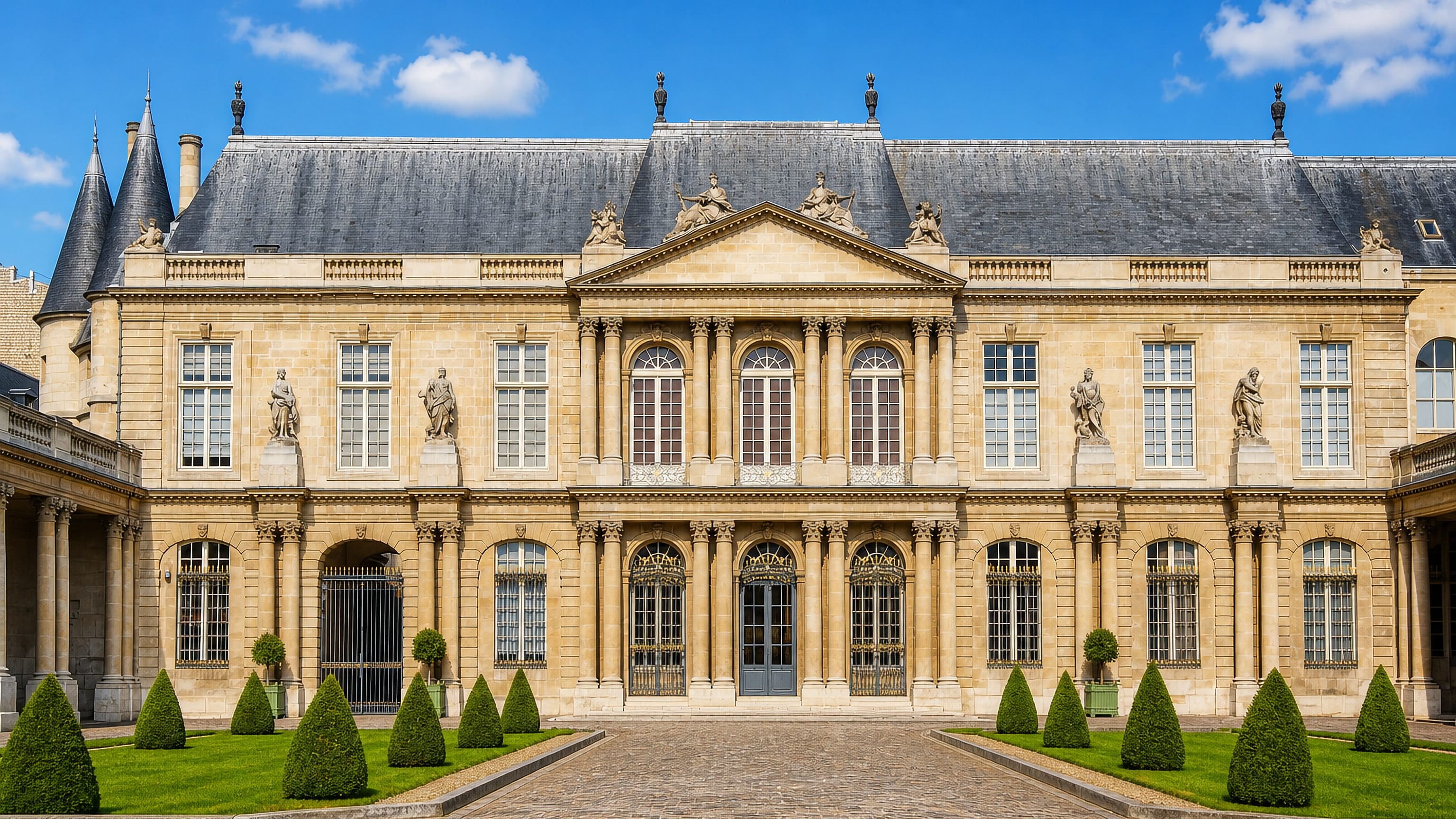 A grand 18th-century hotel particulier facade and its clipped topiary courtyard in Le Marais, Paris.