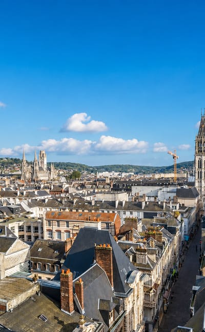 Rouen's Gothic cathedral with its tall cast-iron spire rising over red-tiled rooftops and the Palais de Justice.
