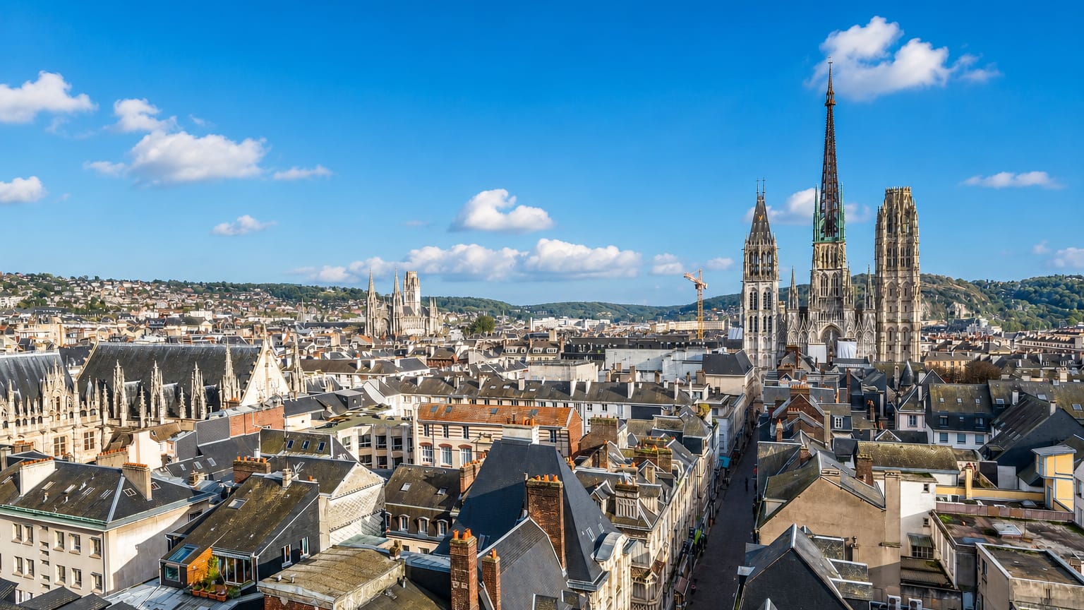 Rouen's Gothic cathedral with its tall cast-iron spire rising over red-tiled rooftops and the Palais de Justice.
