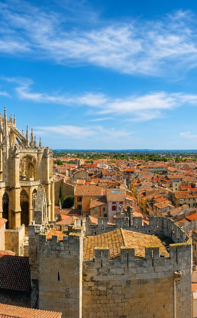 Narbonne's Gothic Cathedral of Saint-Just and the crenellated archbishops' palace tower rising above terracotta rooftops