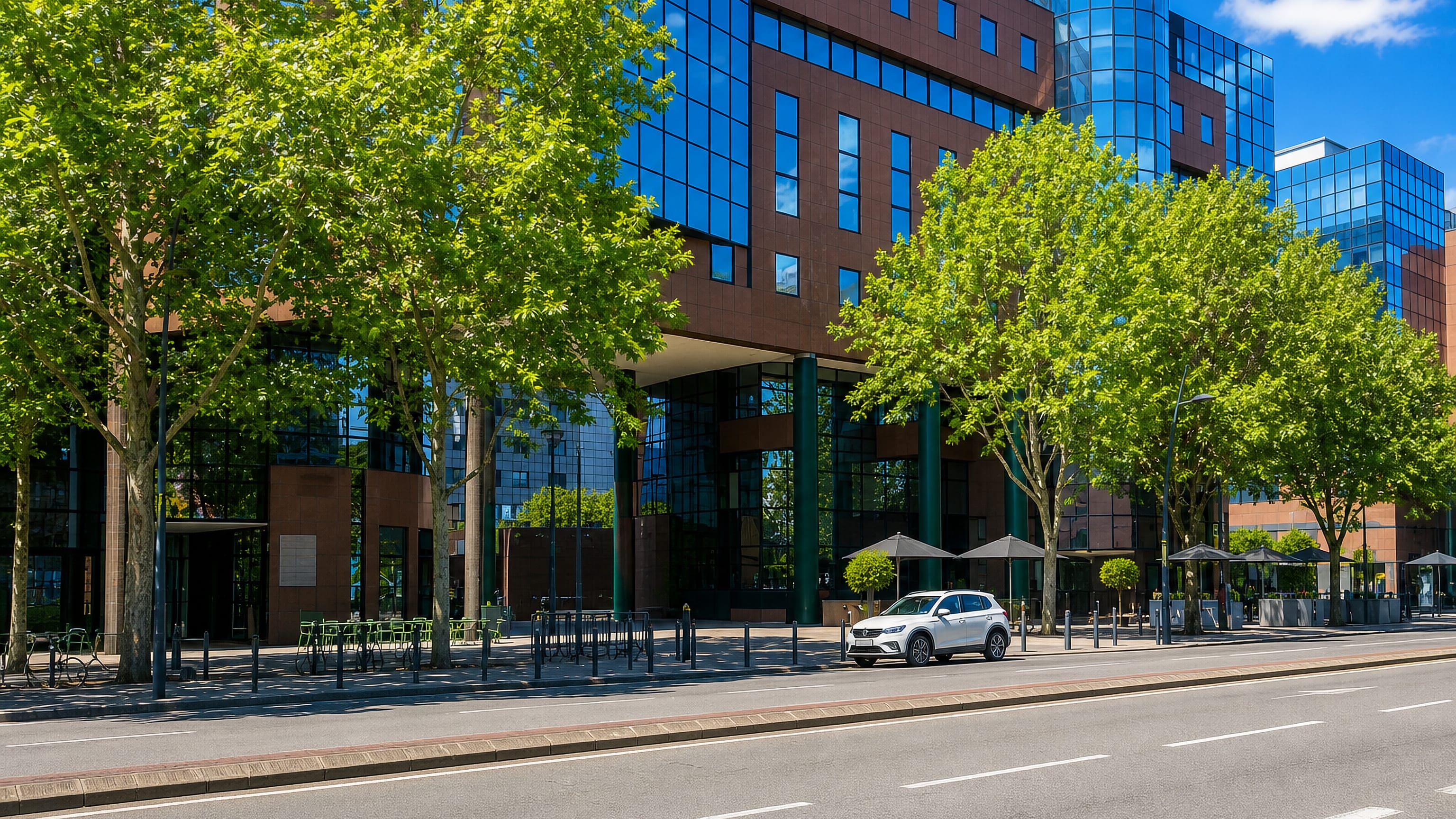 Glass and brick office towers behind plane trees on a boulevard in the Compans business quarter of Toulouse.