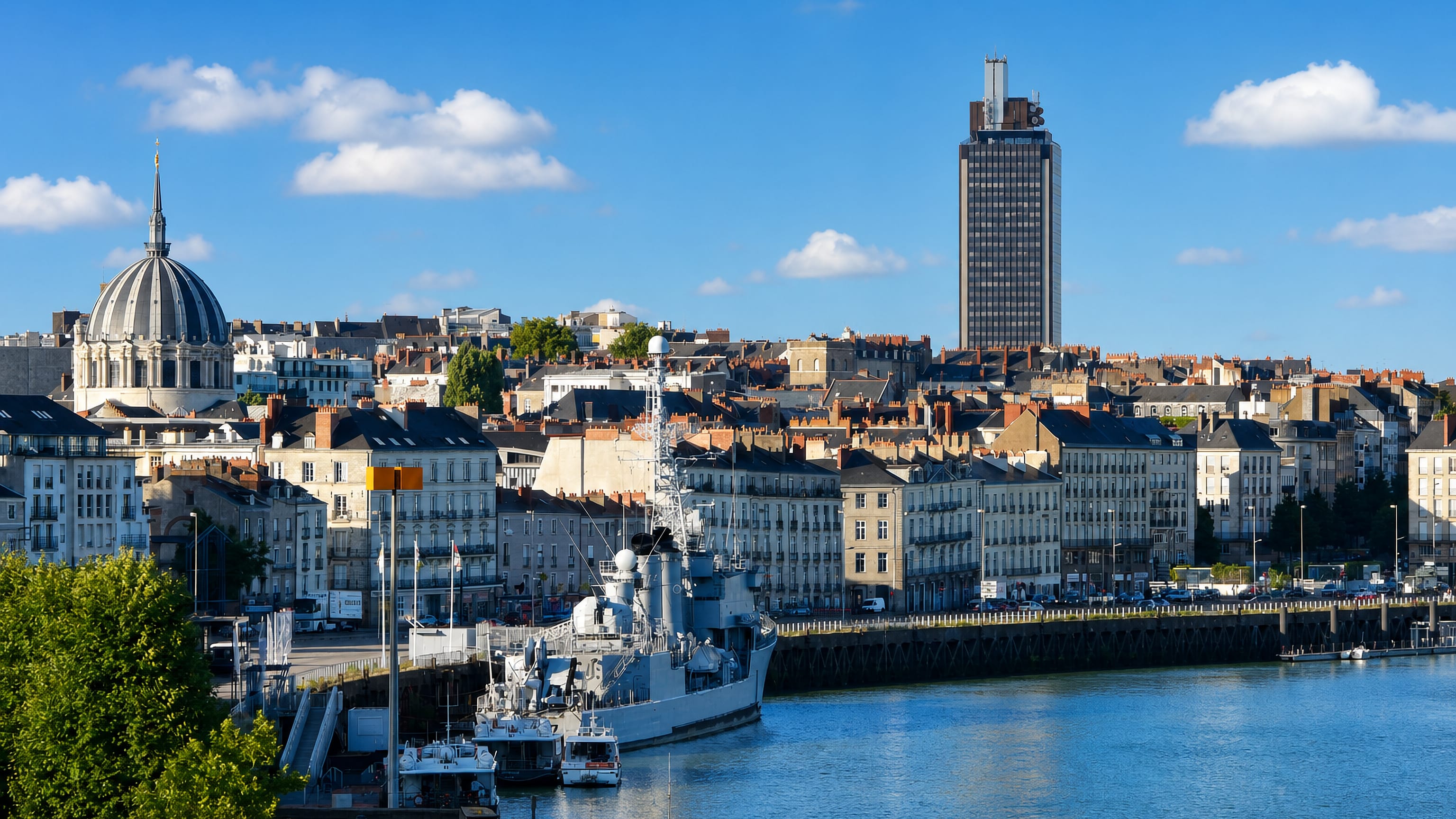 Nantes' Loire waterfront with the Maille-Breze warship, the domed Notre-Dame de Bon-Port basilica and the Tour Bretagne.