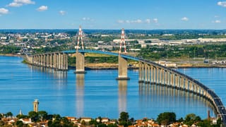 The cable-stayed Pont de Saint-Nazaire spanning the Loire estuary above red-roofed houses at Saint-Nazaire, France.