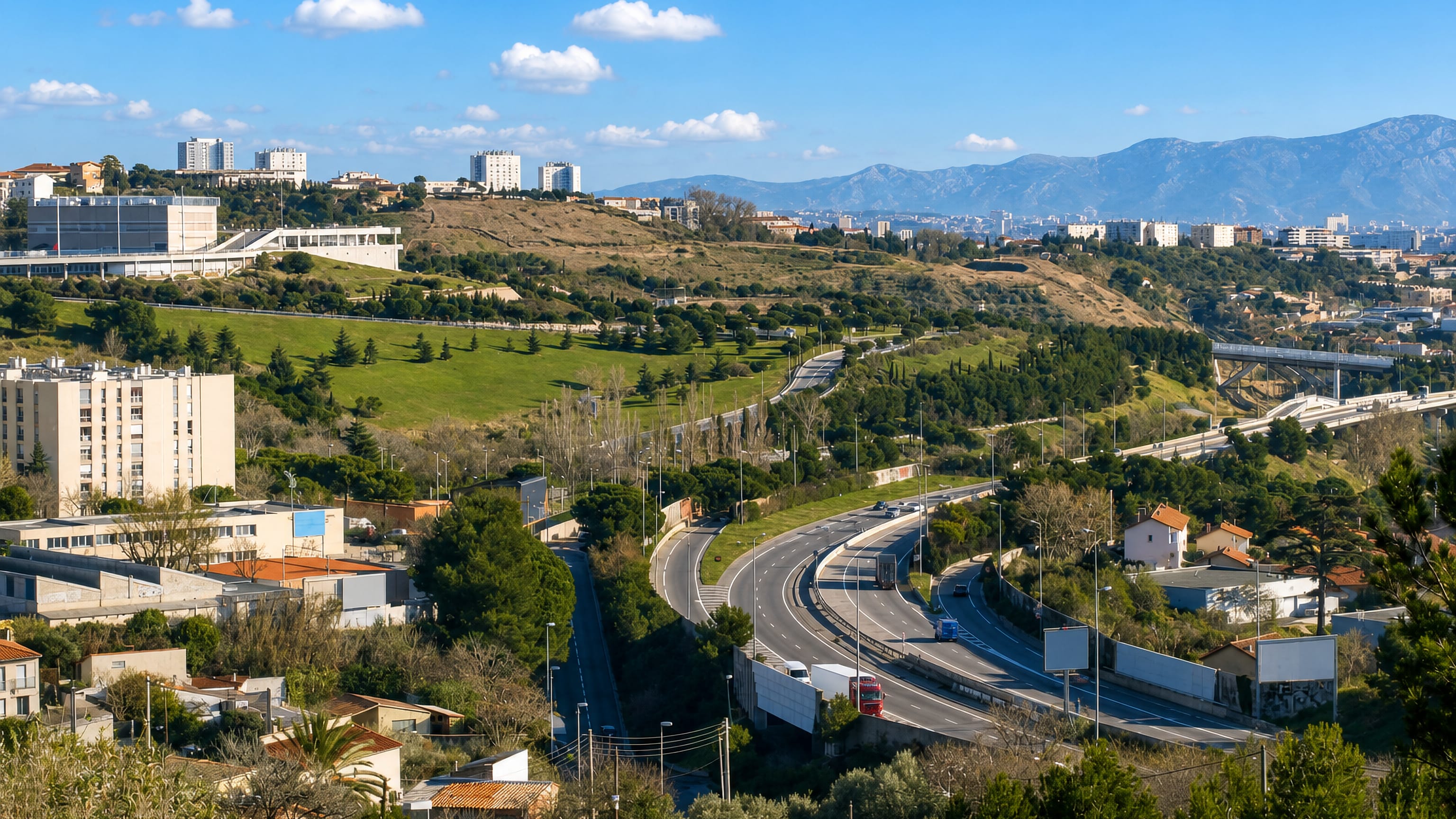 Hilltop housing blocks above the motorway winding through the valley at La Viste in northern Marseille.
