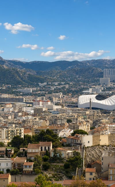 Panorama of Saint-Giniez, Marseille, with the Stade Velodrome and limestone hills behind the rooftops.