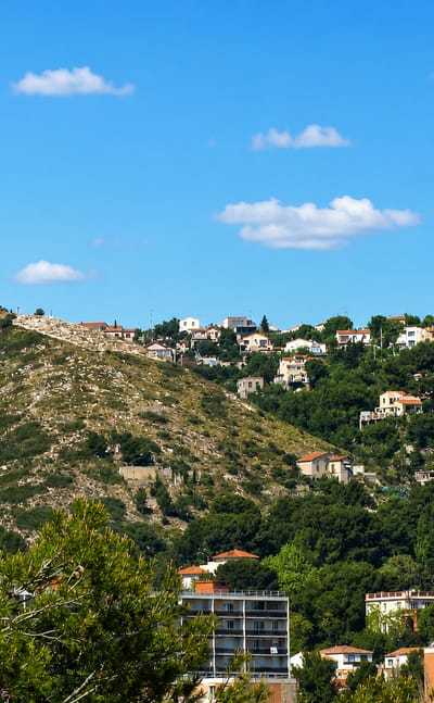 Houses scattered across pine-covered hillsides above apartment blocks in Verduron, northern Marseille.